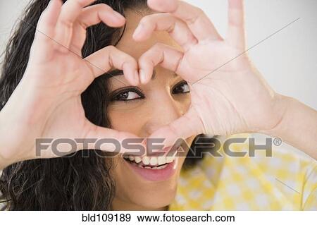 Hispanic woman making heart shape with fingers View Large Photo Image Stock Photo - Hispanic woman making heart shape with fingers. Fotosearch