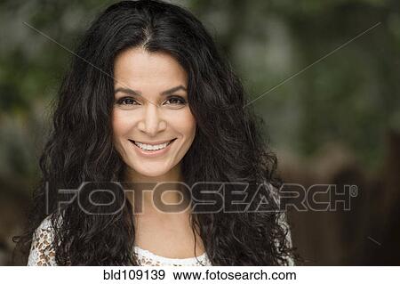 Stock Photo - Hispanic woman smiling outdoors. Fotosearch