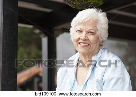 Stock Image - Hispanic woman standing outdoors. Fotosearch
