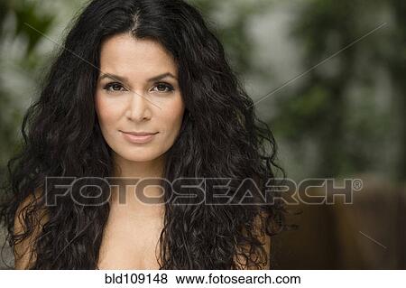 Stock Photo - Hispanic woman standing outdoors. Fotosearch