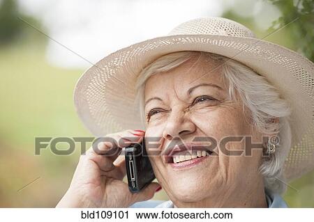 Stock Image - Hispanic woman talking on cell phone. Fotosearch