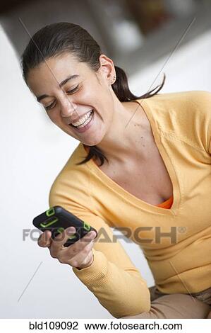 Stock Image - Hispanic woman using cell phone. Fotosearch