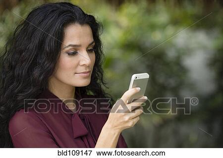 Stock Photo - Hispanic woman using cell phone. Fotosearch