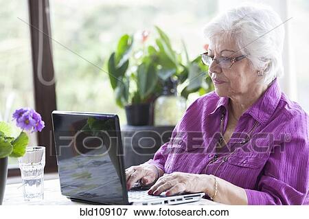 Stock Photo - Hispanic woman using laptop. Fotosearch