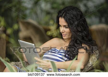 Stock Photo - Hispanic woman using tablet computer. Fotosearch