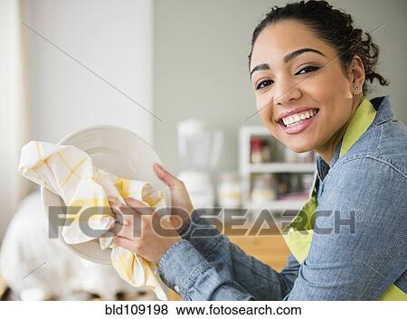 Stock Photo - Hispanic woman wiping plate. Fotosearch