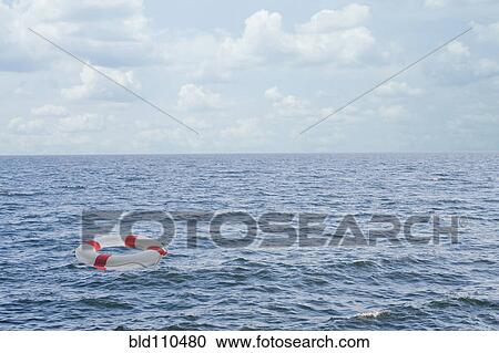 Stock Image - Life preserver floating in open ocean. Fotosearch
