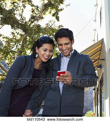 Mixed race couple using cell phone outdoors View Large Photo Image Stock Image - Mixed race couple using cell phone outdoors. Fotosearch