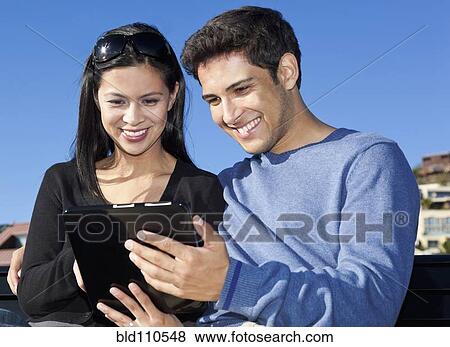 Stock Photo - Mixed race couple using tablet computer. Fotosearch