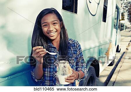 Mixed race girl eating ice cream from truck View Large Photo Image Stock Photography - Mixed race girl eating ice cream from truck. Fotosearch