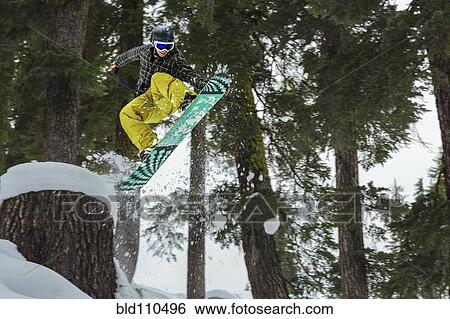 Mixed race snowboarder jumping on snowy slope View Large Photo Image Stock Photograph - Mixed race snowboarder jumping on snowy slope. Fotosearch
