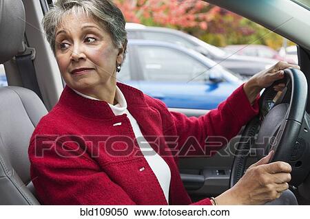 Stock Image - Mixed race woman driving in car. Fotosearch