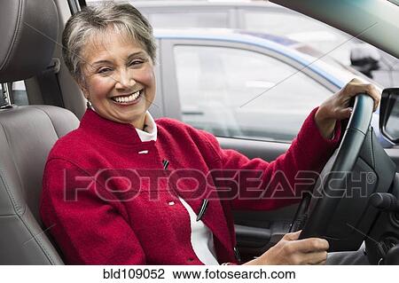 Stock Image - Mixed race woman driving in car. Fotosearch