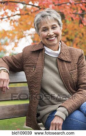 Stock Photo - Mixed race woman on park bench. Fotosearch