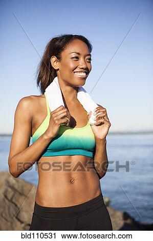 Stock Image - Mixed race woman resting during run. Fotosearch
