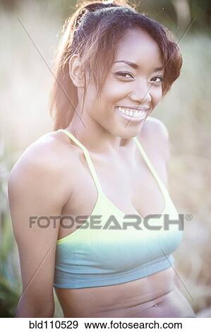 Stock Photo - Mixed race woman sitting outdoors. Fotosearch
