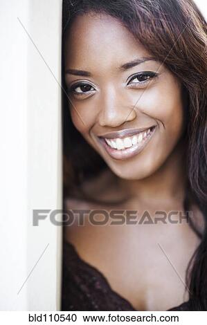 Stock Image - Mixed race woman standing in doorway. Fotosearch