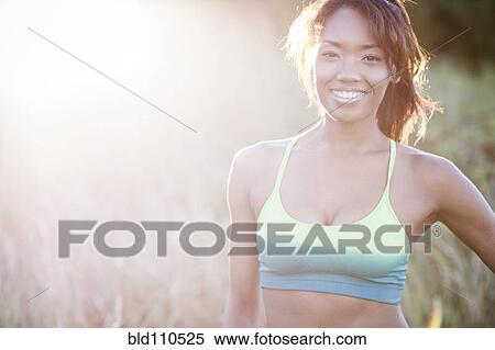 Stock Photography - Mixed race woman standing in field. Fotosearch