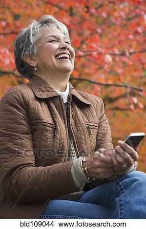 Mixed race woman using cell phone View Large Photo Image Picture - Mixed race woman using cell phone. Fotosearch