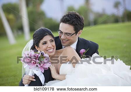 Newlywed couple hugging on golf course View Large Photo Image Stock Photo - Newlywed couple hugging on golf course. Fotosearch
