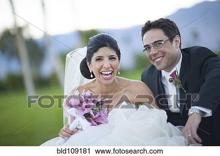 Stock Image - Newlywed couple smiling on golf course. Fotosearch