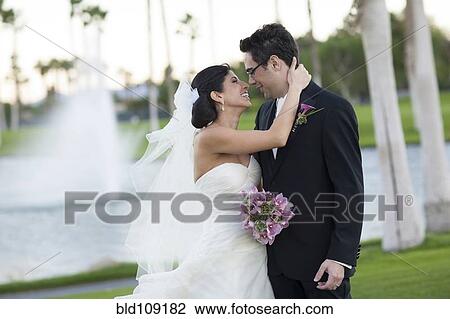Newlywed couple smiling on golf course View Large Photo Image Stock Image - Newlywed couple smiling on golf course. Fotosearch