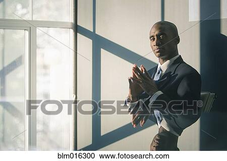 Stock Image - Black businessman sitting at desk. Fotosearch