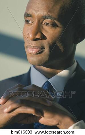 Stock Image - Black businessman with hands folded. Fotosearch