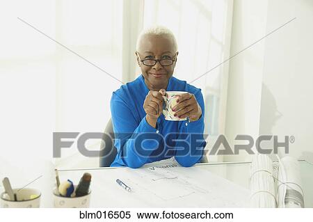 Stock Photography - Black businesswoman drinking coffee. Fotosearch