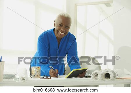 Stock Photo - Black businesswoman taking notes. Fotosearch
