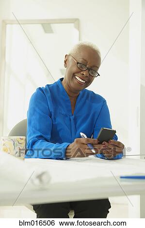 Stock Photograph - Black businesswoman using cell phone. Fotosearch