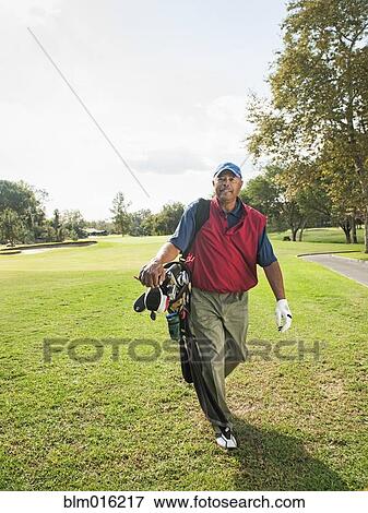 Black man carrying golf clubs View Large Photo Image Stock Photo - Black man carrying golf clubs. Fotosearch