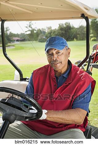 Stock Photography - Black man driving golf cart. Fotosearch
