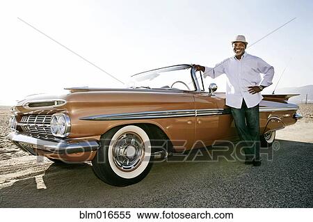 Stock Photography - Black man leaning on convertible. Fotosearch