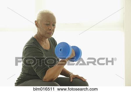 Stock Image - Black woman lifting weights. Fotosearch
