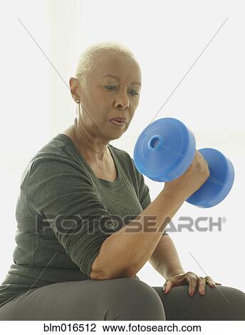Stock Image - Black woman lifting weights. Fotosearch