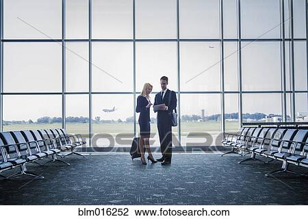 Stock Image - Caucasian business people standing in airport. Fotosearch