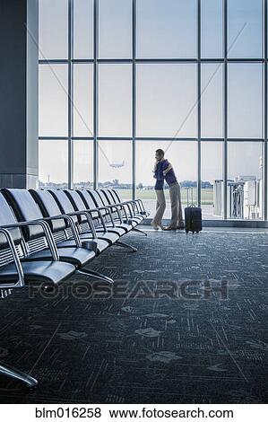 Stock Photo - Caucasian couple hugging in airport. Fotosearch