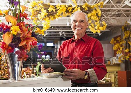Caucasian florist using tablet computer in shop View Large Photo Image Stock Photo - Caucasian florist using tablet computer in shop. Fotosearch