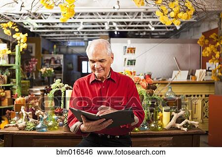 Stock Photograph - Caucasian florist using tablet computer in shop. Fotosearch