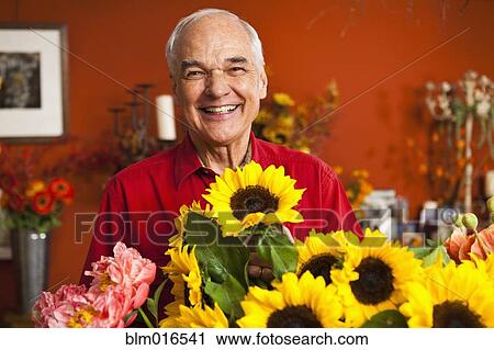 Stock Image - Caucasian florist with bouquet in shop. Fotosearch
