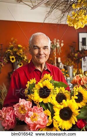 Stock Image - Caucasian florist with bouquet in shop. Fotosearch
