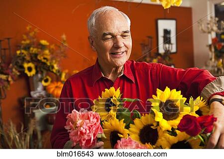 Stock Image - Caucasian florist with bouquet in shop. Fotosearch