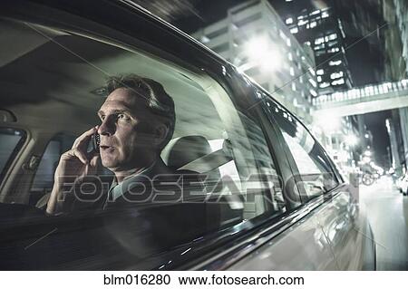 Stock Image - Caucasian man driving and talking on cell phone. Fotosearch