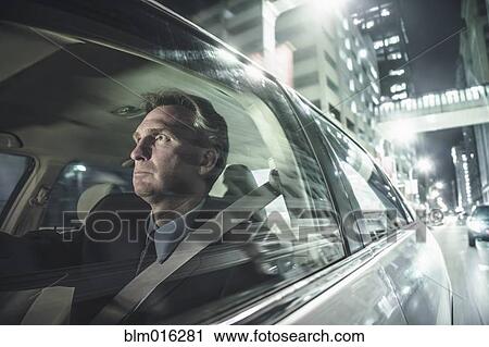 Stock Image - Caucasian man driving on city street. Fotosearch