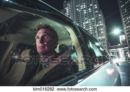 Stock Image - Caucasian man driving on city street. Fotosearch