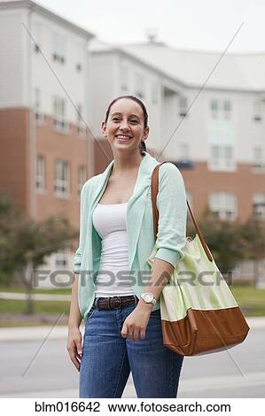 Stock Image - Caucasian student walking on campus. Fotosearch