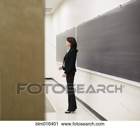 Stock Image - Caucasian teacher at blackboard. Fotosearch