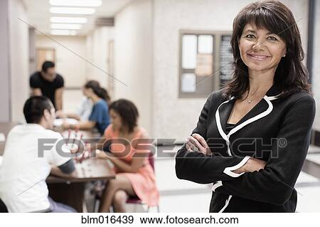 Stock Photo - Caucasian teacher smiling in hallway. Fotosearch