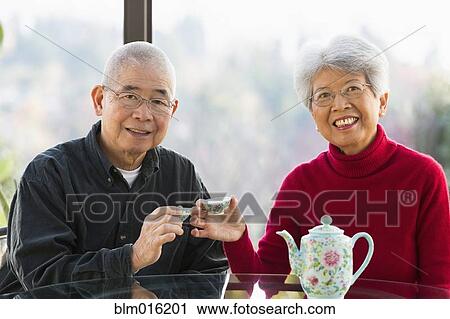 Stock Image - Chinese couple having tea together. Fotosearch